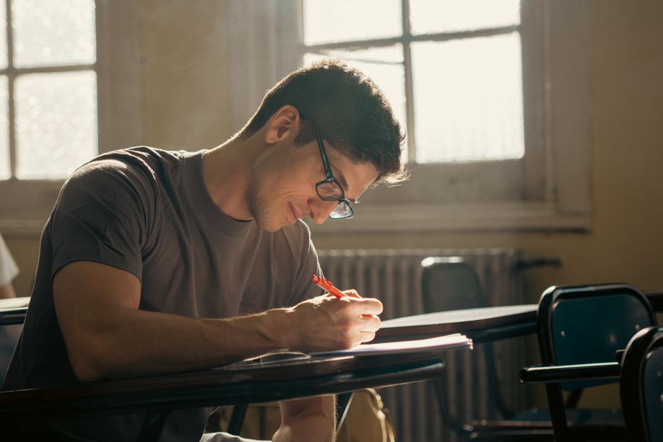 A student writing at a desk